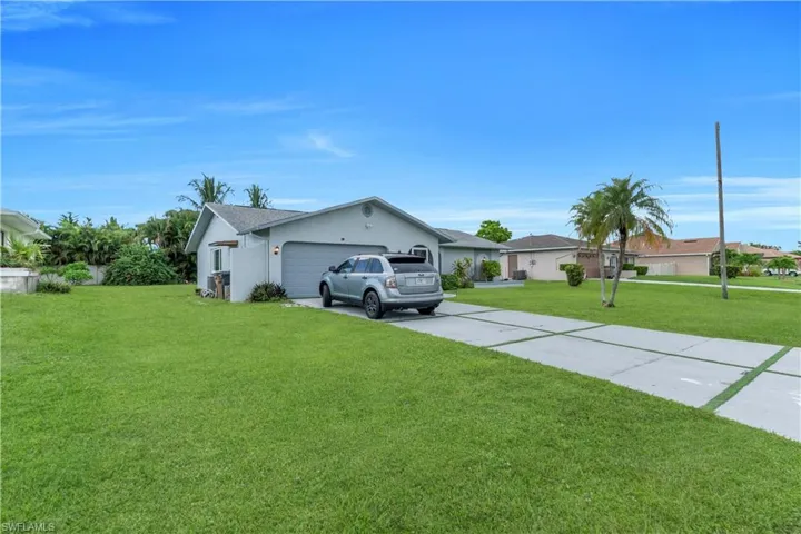 Ranch-style house featuring concrete driveway, a front yard, a garage, and stucco siding
