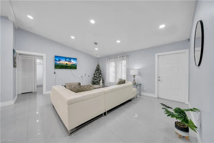 Living area with recessed lighting, vaulted ceiling, and light tile patterned floors