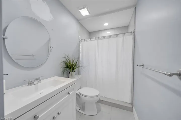 Bathroom with vanity, curtained shower, and light tile patterned flooring