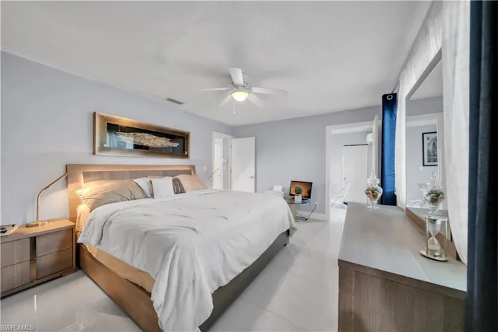 Bedroom with ceiling fan and light tile patterned flooring