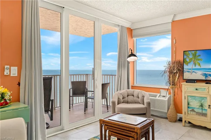 Floor-to-ceiling glass doors open to an outdoor balcony with metal railings