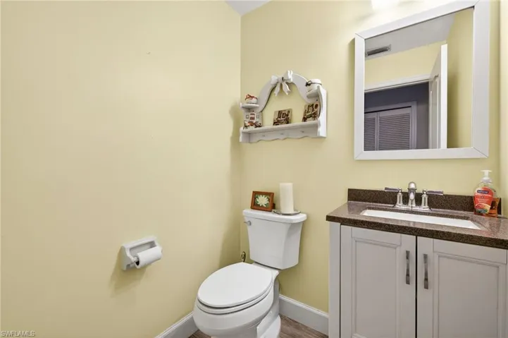 Half bathroom featuring vanity and toilet