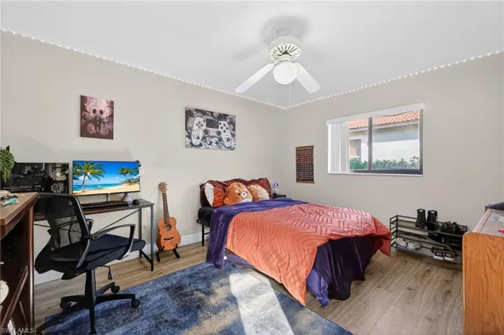 Bedroom with an office area, wood finished floors, and ceiling fan