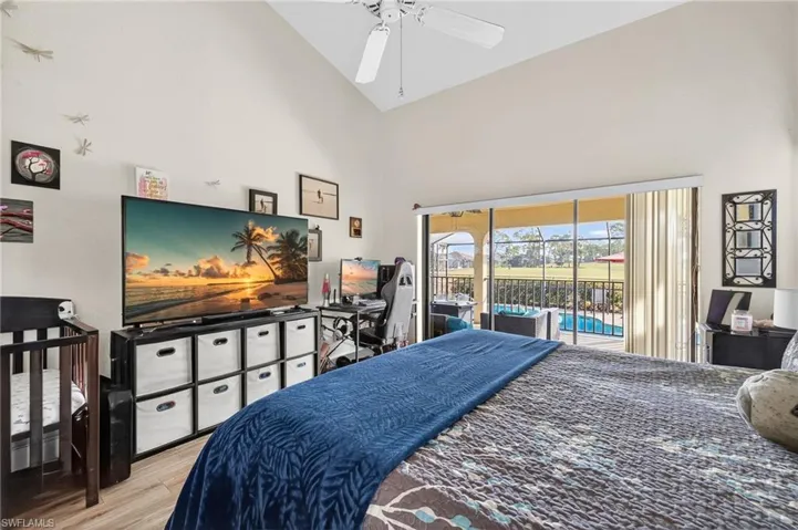 Bedroom with vaulted ceiling, wood finished floors, a ceiling fan, access to outside,