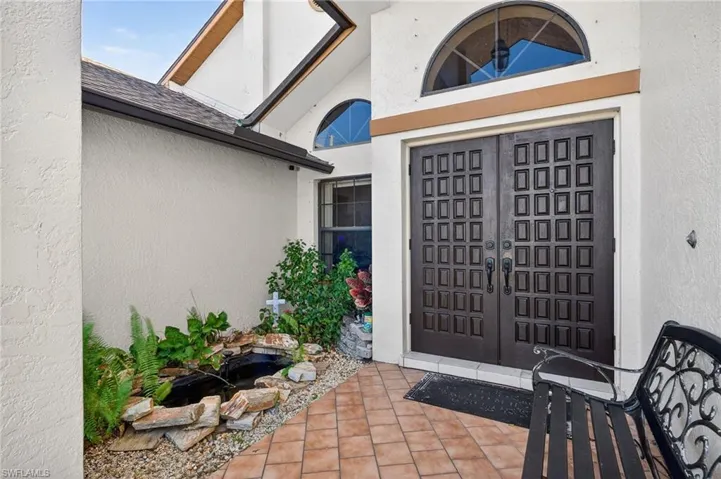 View of exterior entry featuring stucco siding and french doors
