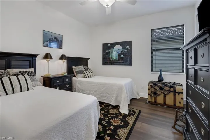 Bedroom with ceiling fan and dark hardwood / wood-style floors
