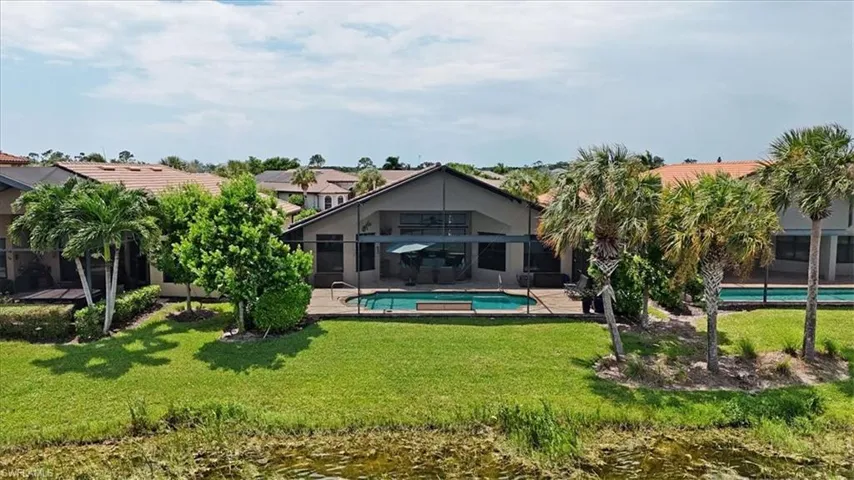 Back of house featuring a lanai, a patio, and a yard