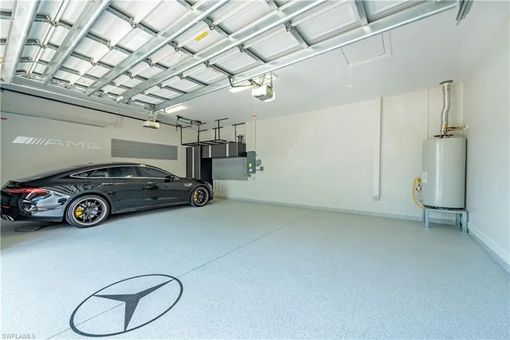 Garage featuring a garage door opener and gas water heater