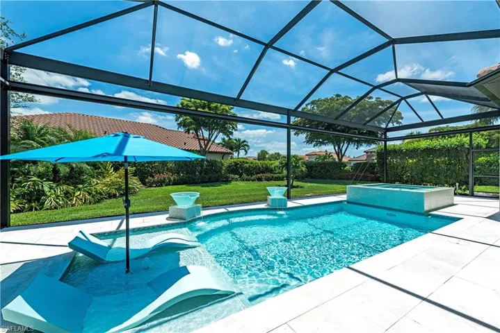 View of pool with glass enclosure, a patio area, and a yard