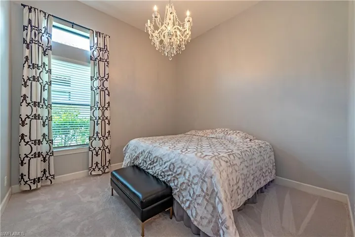 Bedroom with carpet floors and an inviting chandelier