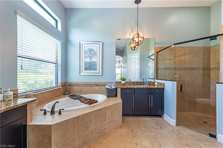 Bathroom with a healthy amount of sunlight, vanity, tile floors, and shower with separate bathtub