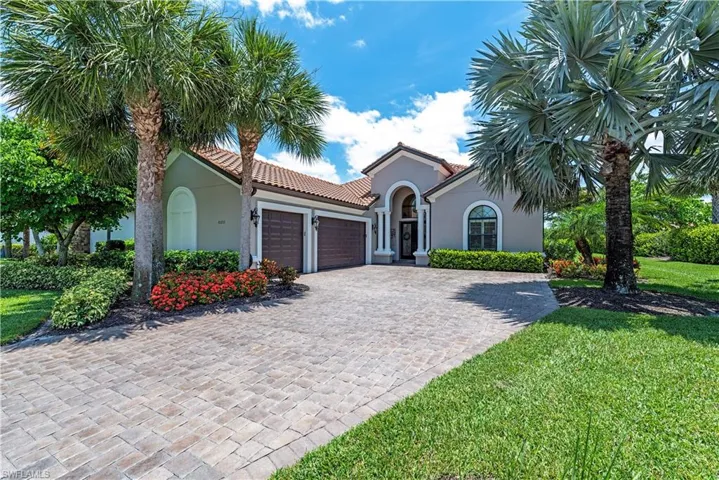 Mediterranean / spanish-style home featuring a garage and a front yard