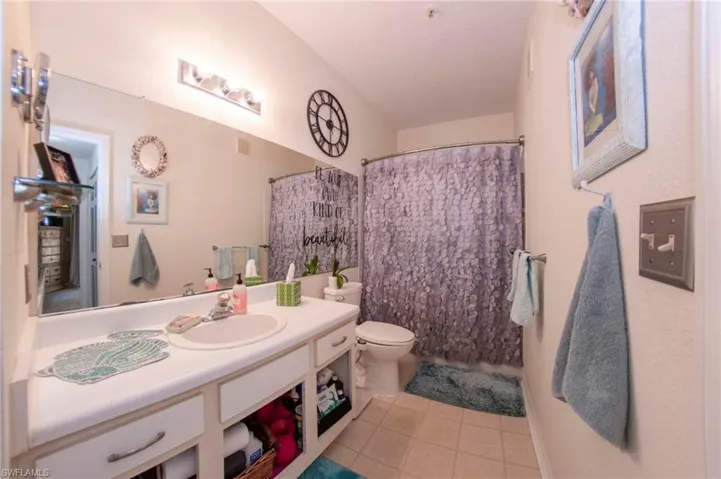 Bathroom featuring tile patterned flooring, toilet, and vanity