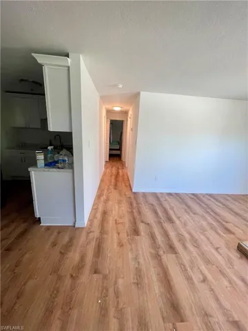Corridor featuring a textured ceiling, light hardwood / wood-style floors, and sink