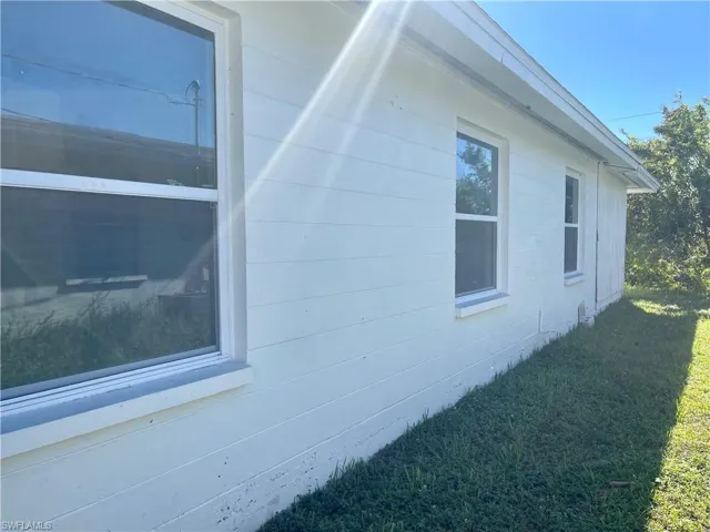 View of side of home with a lawn