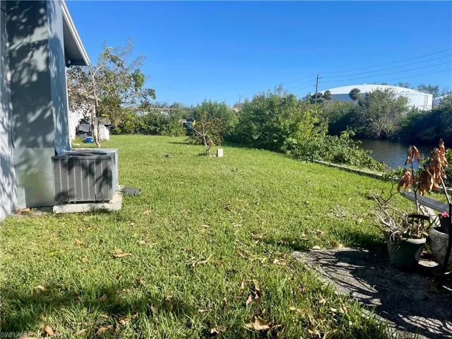 View of yard with a water view and central AC