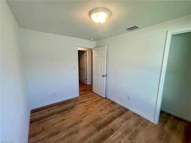 Unfurnished bedroom with hardwood / wood-style floors, a textured ceiling, and a closet