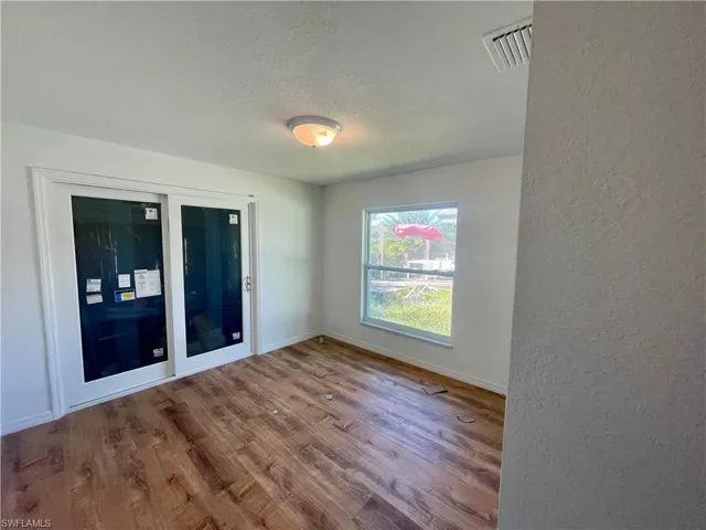 Empty room featuring hardwood / wood-style floors and a textured ceiling
