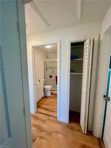 Corridor with light hardwood / wood-style floors and a textured ceiling