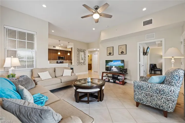 Living area with light tile patterned flooring, recessed lighting, and ceiling fan