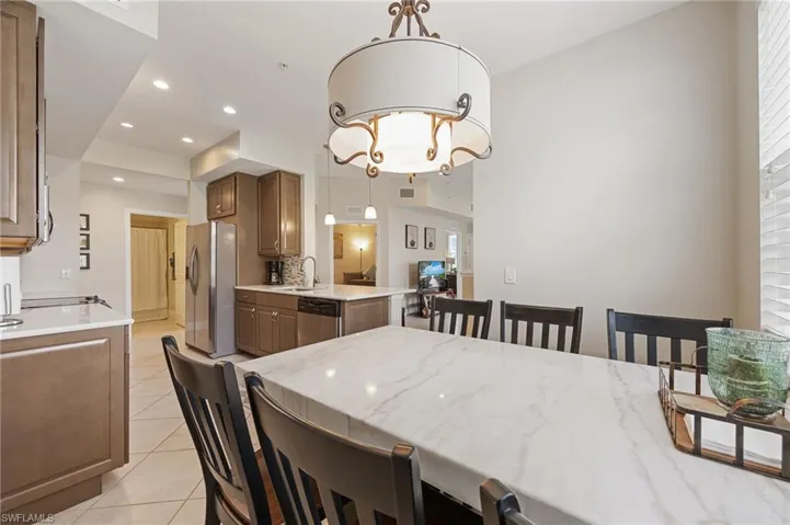 Dining room with light tile patterned floors, recessed lighting, and a chandelier