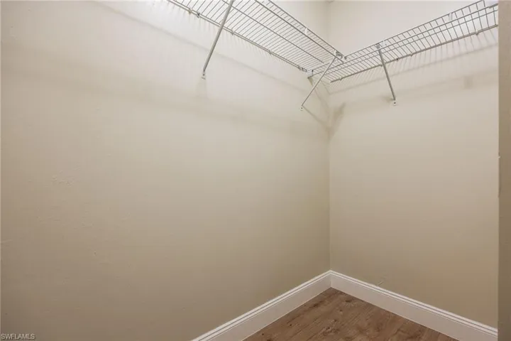Walk in closet with wood finished floors