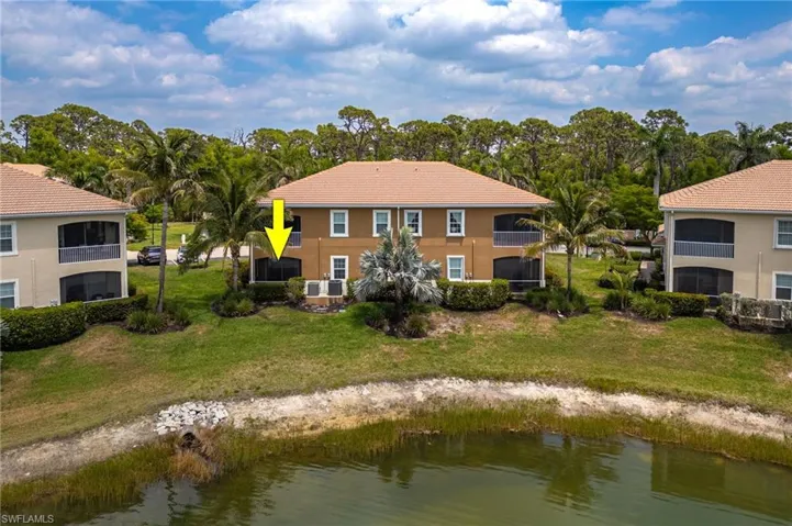 Rear view of house featuring a water view, view of scattered trees, and a yard