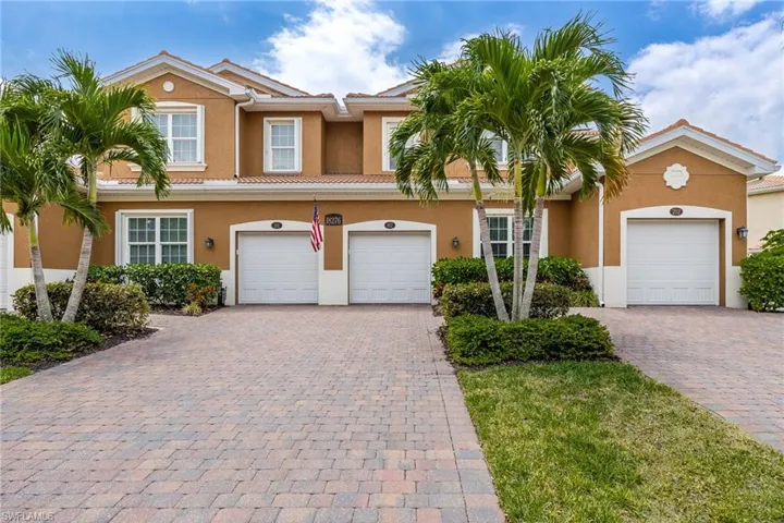 View of front of property with decorative driveway, stucco siding, and a tiled roof
