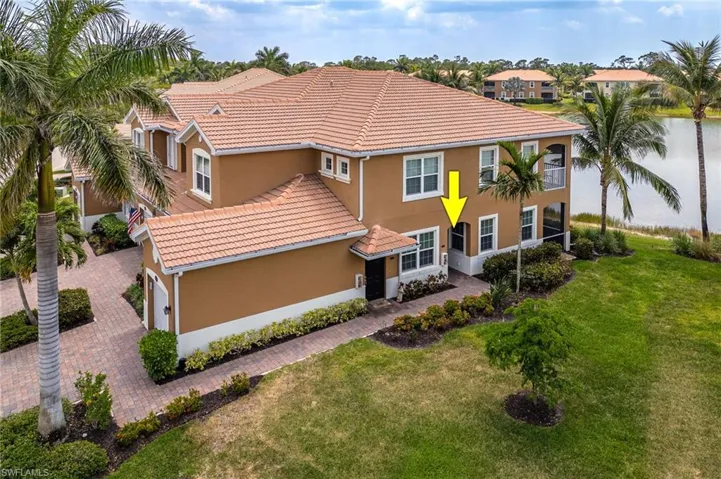View of front of house with stucco siding, a tiled roof, and a front yard