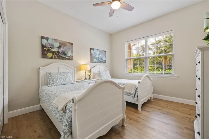 Guest Bedroom with wood finished floors and ceiling fan