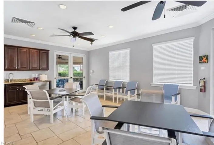 Community dining area featuring light tile patterned floors, ornamental molding, recessed lighting, and a ceiling fan