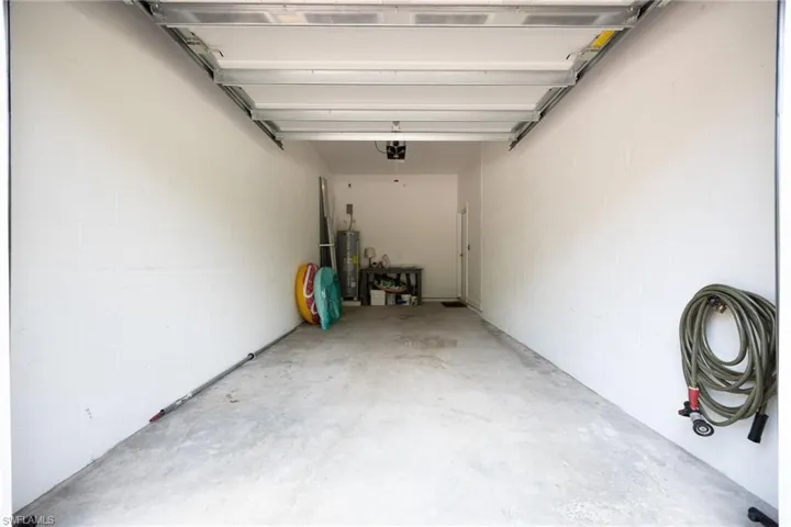 Garage featuring water heater and concrete block wall