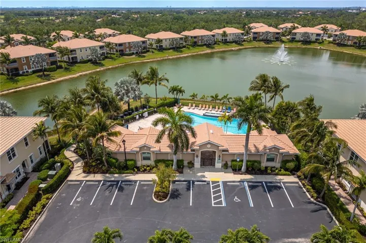 Drone / aerial view of a nearby body of water and a pool area