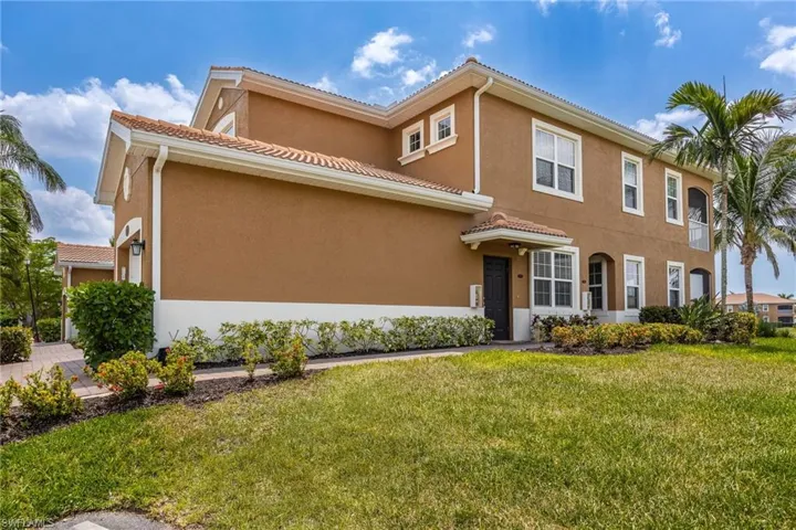 Mediterranean / spanish house with stucco siding, a front lawn, and a tile roof
