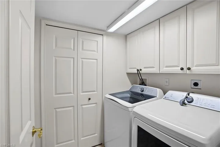Laundry area featuring independent washer and dryer and cabinet space