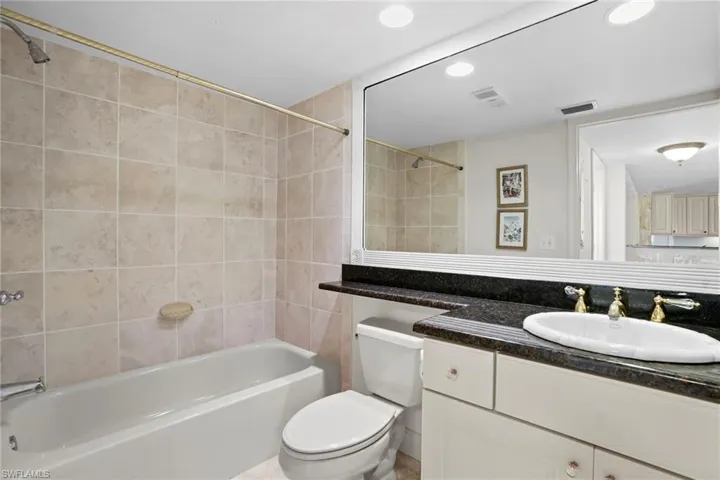 Bathroom with vanity, shower / tub combination, and recessed lighting