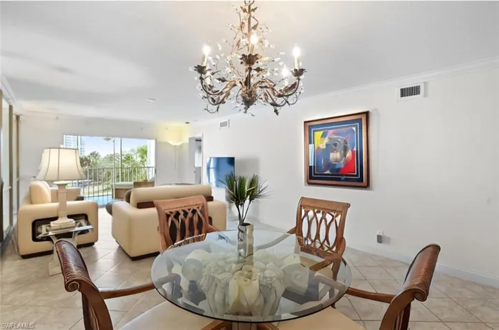 Dining area-partial staged-with ornamental molding and suspended lighting