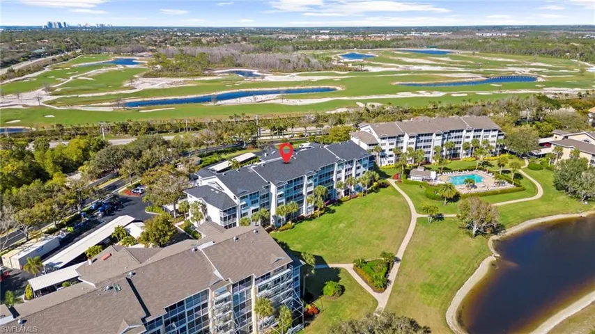 Aerial view of property's location featuring a nearby body of water and a golf course