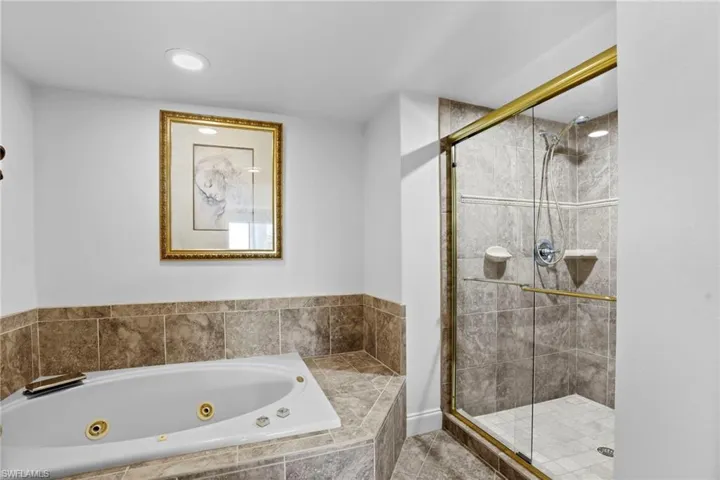 Full bathroom with a stall shower and a tub with jets
