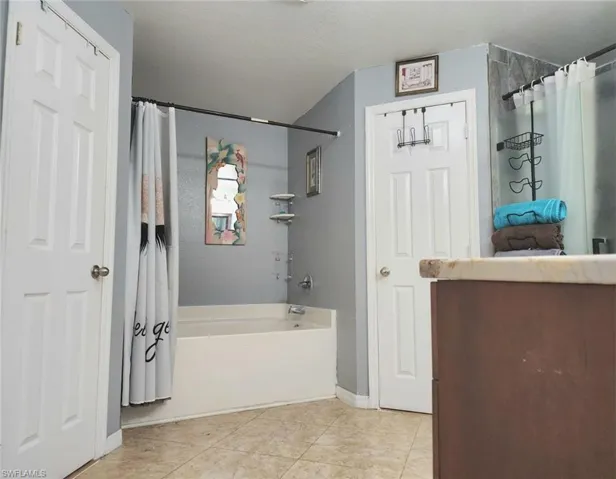 Bathroom with plus walk in shower, tile patterned floors, a textured ceiling, and vanity