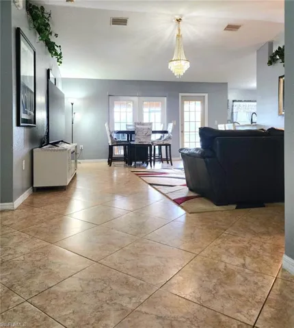 Tiled living room featuring a chandelier