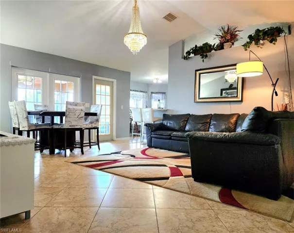 Living room featuring a notable chandelier and vaulted ceiling
