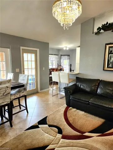 Tiled living room featuring a notable chandelier