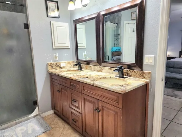 Bathroom featuring vanity, an enclosed shower, and tile patterned floors
