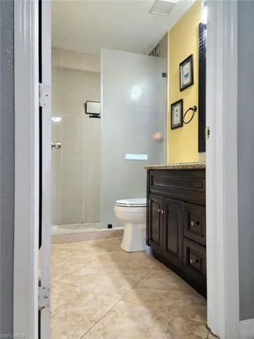 Bathroom with vanity, toilet, and a tile shower