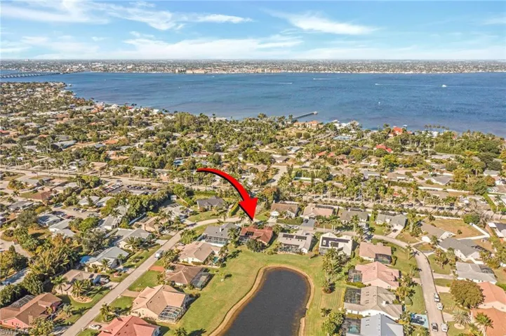 Aerial view of property and surrounding area with a large body of water and nearby suburban area