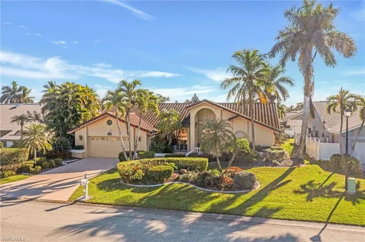 Mediterranean / spanish house featuring stucco siding, driveway, a garage, and a front yard