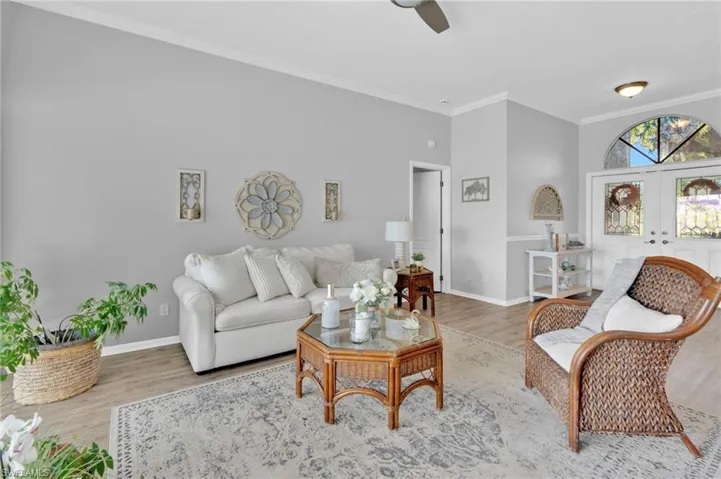 Living room featuring ornamental molding, wood finished floors, and french doors