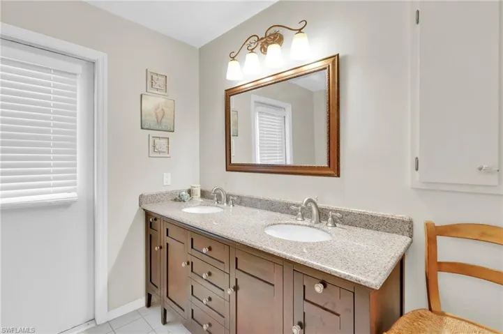 Full bathroom with double vanity and light tile patterned floors