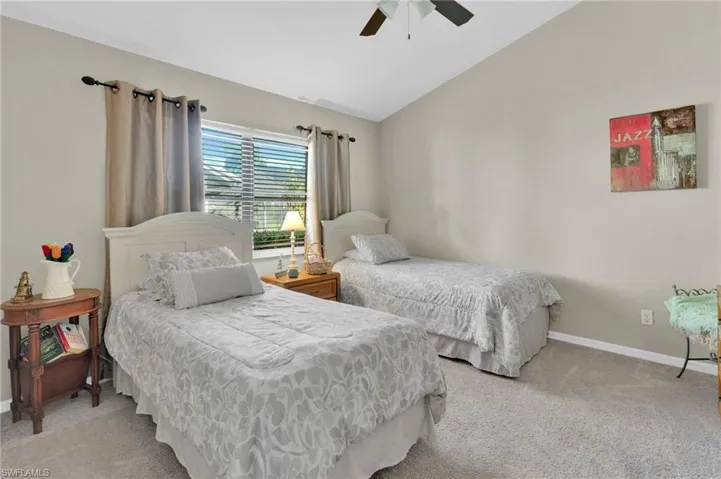 Bedroom featuring vaulted ceiling, light colored carpet, and ceiling fan